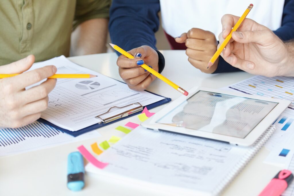 Collaborative work. Group of marketing experts working together on startup project, sitting at table